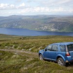 Blauer Land Rover Freelander in der Seiten- Heckansicht